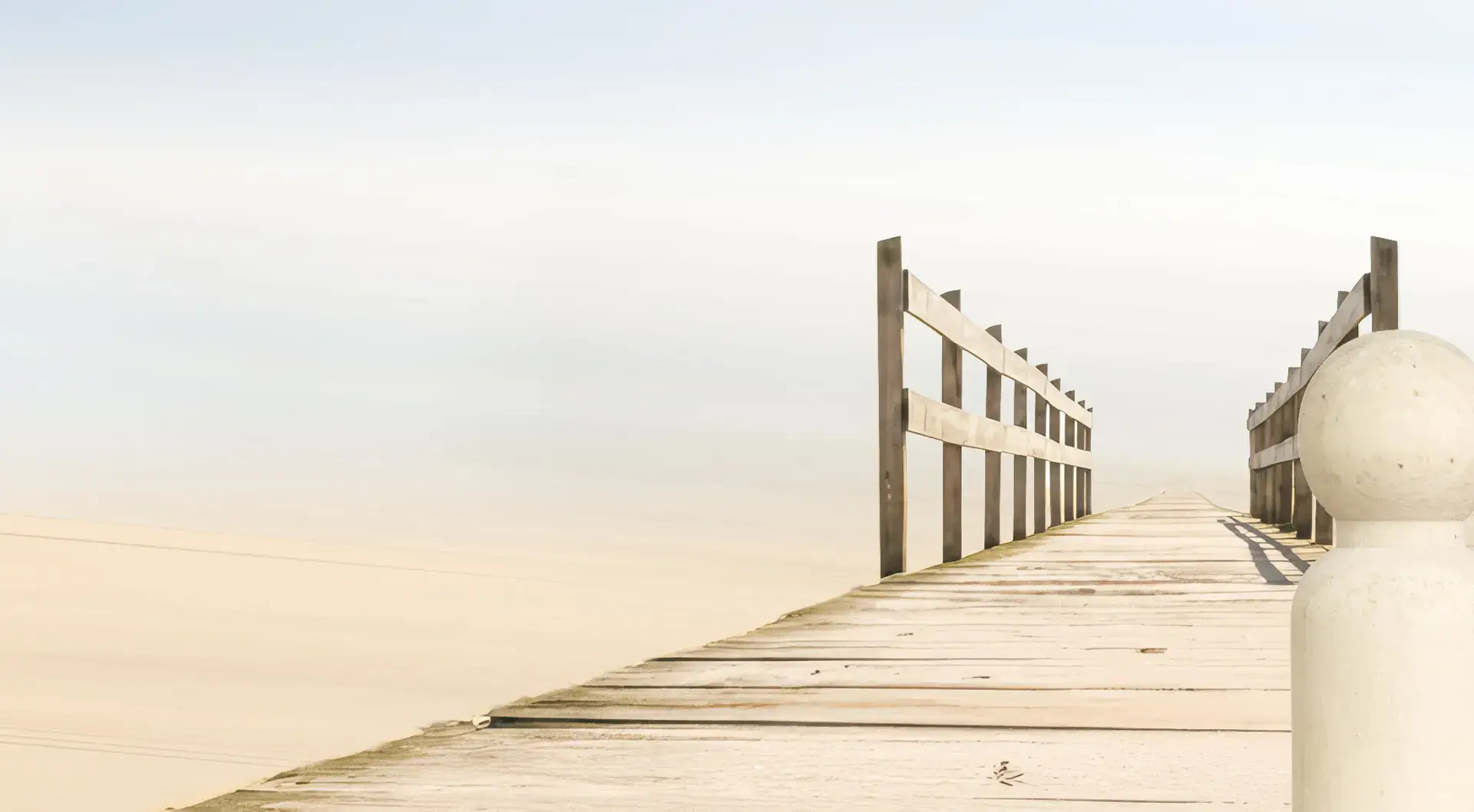 Heller Holzsteg am ruhigen Wasser mit seitlichen Geländern und weichem Morgenlicht, das eine klare, ruhige Atmosphäre für Veränderung schafft.